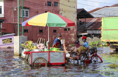 People riding bicycles on sidewalk in city