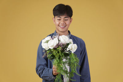 Portrait of smiling man standing against orange wall