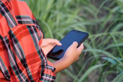 Midsection of man using mobile phone