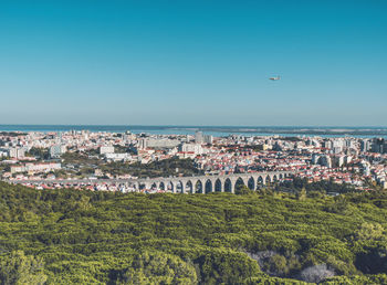 Aerial view of city against blue sky