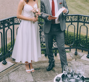 Low section of friends standing on railing