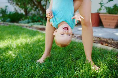 Low section of woman sitting on grassy field