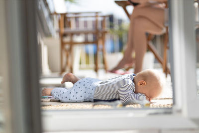 Portrait of cute baby boy sitting on bed at home