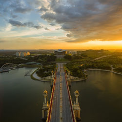 High angle view of suspension bridge in city during sunset