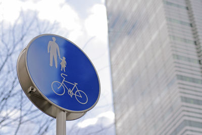 Low angle view of road sign against blue sky