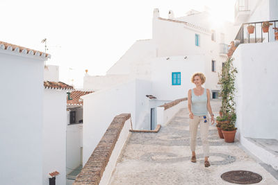 Full length of woman standing outside house