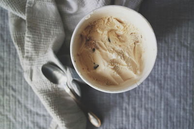 Directly above shot of ice cream on container on bed