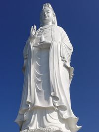 Low angle view of statue against clear blue sky