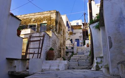 Alley amidst buildings against blue sky