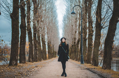 Full length of man standing on footpath in forest