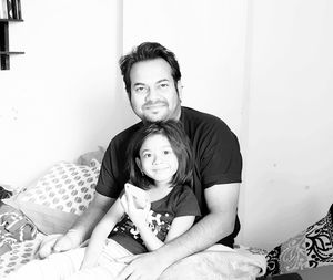 Portrait of smiling girl sitting on bed