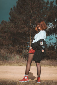 Full length of girl standing by tree