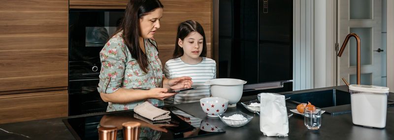 Portrait of young woman sitting in kitchen