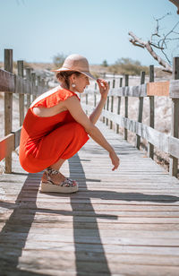 Full length of woman crouching on footbridge