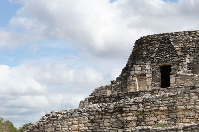 Low angle view of old building against cloudy sky