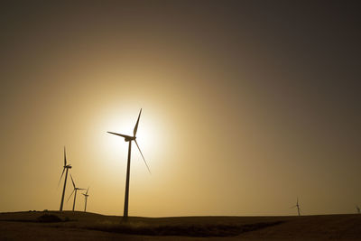 Windmills for electric power production at sunrise.