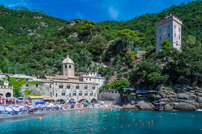 Buildings by sea against sky