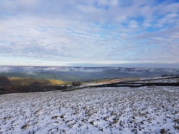 Scenic view of snow covered field against sky