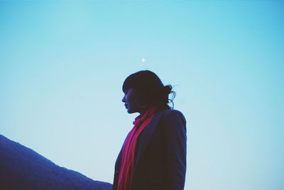 Woman standing against clear blue sky