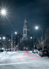 Illuminated city street and buildings at night during winter