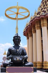 Black statue buddha siting outdoor in temple of uthai thani, thailand