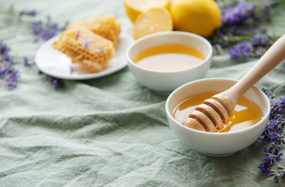 Bowls of honey, honeycomb and lavender flowers