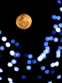 Low angle view of illuminated moon at night