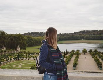 Rear view of woman standing against lake