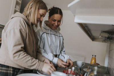 Smiling homosexual couple preparing food together