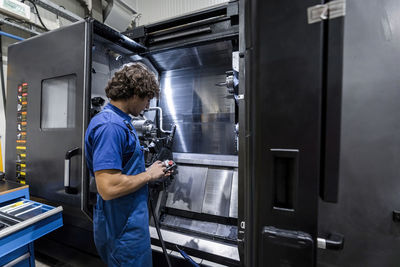 Rear view of man working in factory