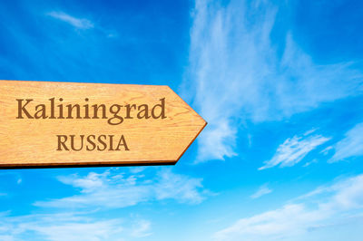 Low angle view of information sign against blue sky