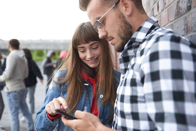 Young couple standing on mobile phone