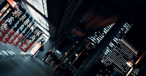 High angle view of people walking in illuminated building