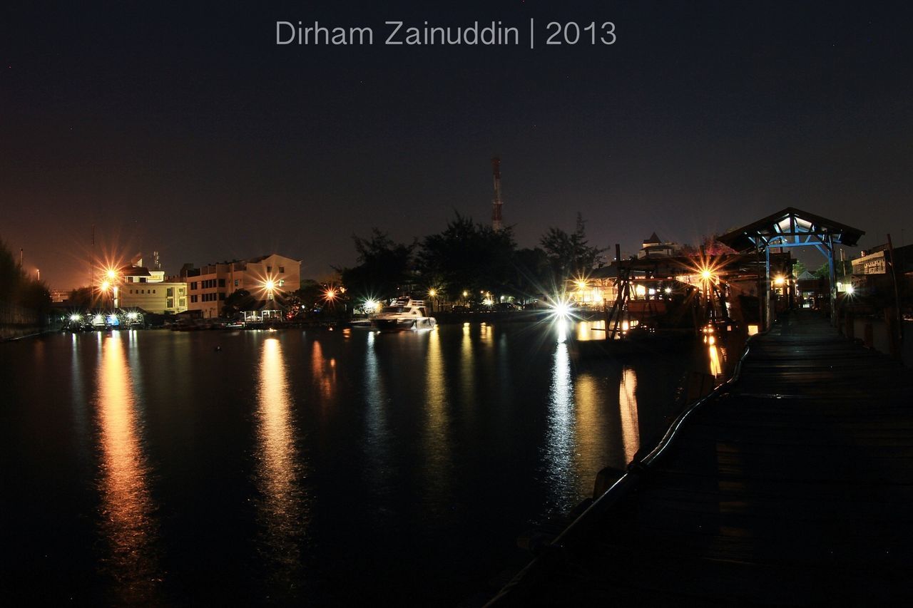 illuminated, night, water, building exterior, built structure, architecture, street light, reflection, city, lighting equipment, river, sky, clear sky, waterfront, transportation, street, the way forward, outdoors, canal, light - natural phenomenon