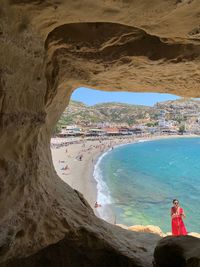 People standing on rock by sea