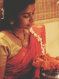 Portrait of beautiful young woman with red flower