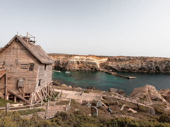 Buildings by sea against clear sky