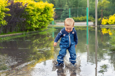 Full length of boy standing on puddle