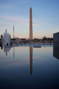 Reflection of built structure in water at sunset