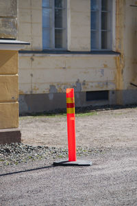 Red arrow sign on street by building