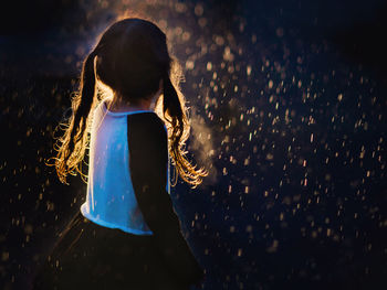 Side view of girl standing outdoors during monsoon at sunset