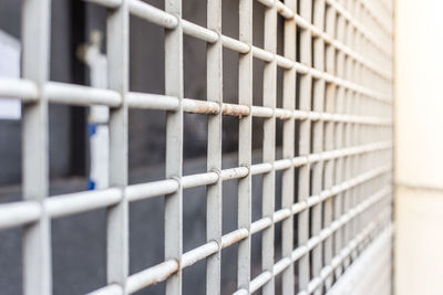 Close-up of metal fence against wall