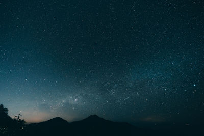 Low angle view of silhouette mountain against star field