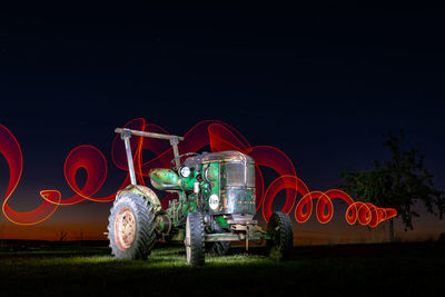 Illuminated ferris wheel against sky at night