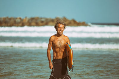 Portrait of shirtless man standing on beach