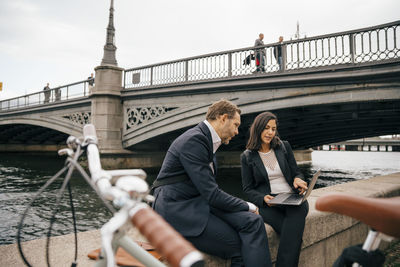 People on bridge over river in city