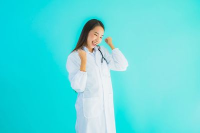 Woman standing against blue wall