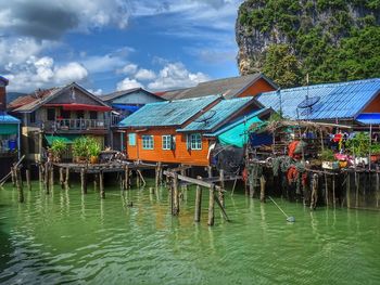 Houses by lake against sky