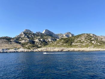 Scenic view of sea and mountains against clear blue sky in marseille 