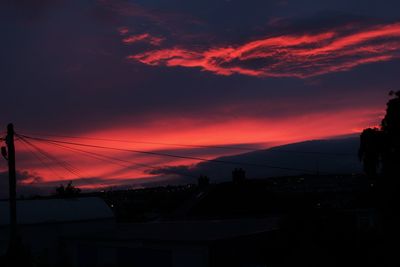 Scenic view of silhouette mountains against orange sky